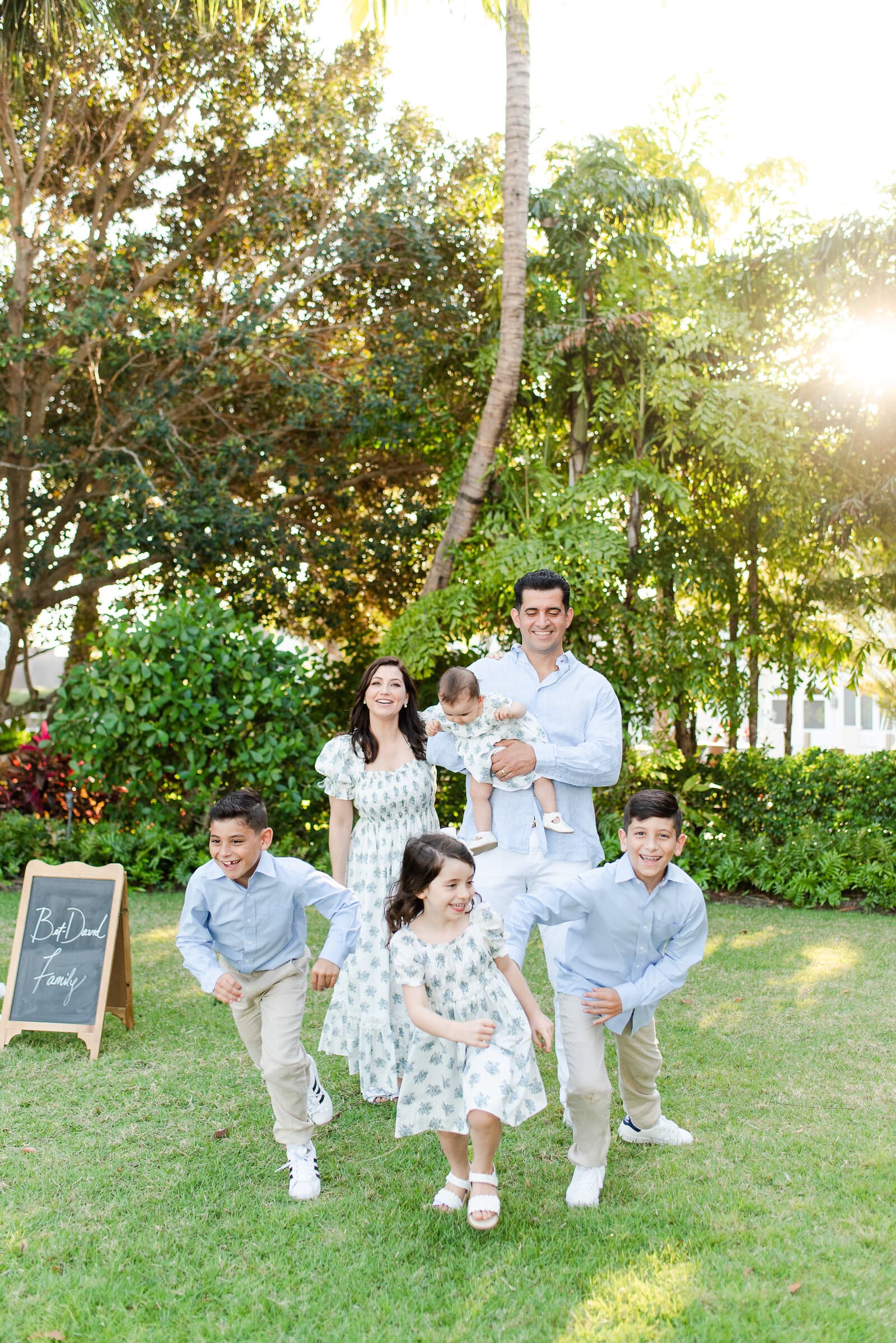Family laughing and running together during a South Florida lifestyle session