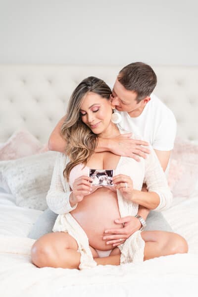 Expecting parents smiling together during a bright maternity portrait