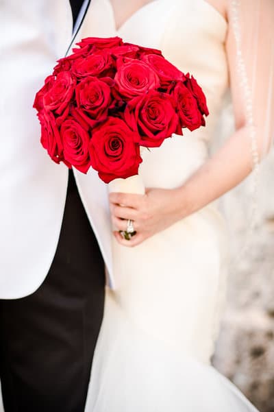 Bride holding a red rose bouquet in a bright wedding portrait
