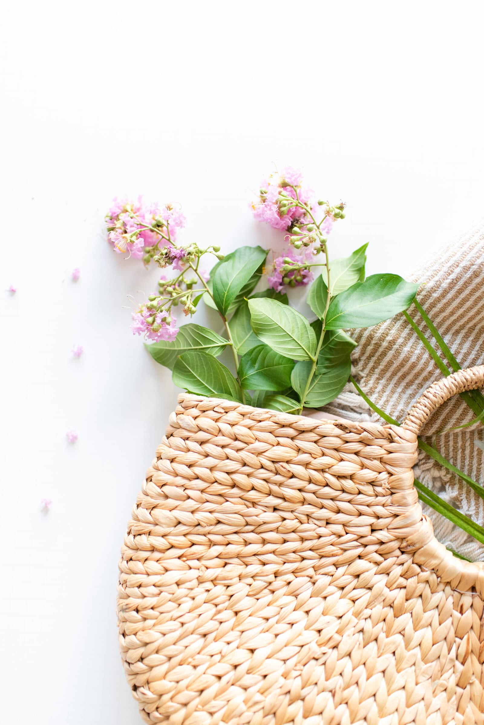 Bright product styling with woven basket and summer flowers